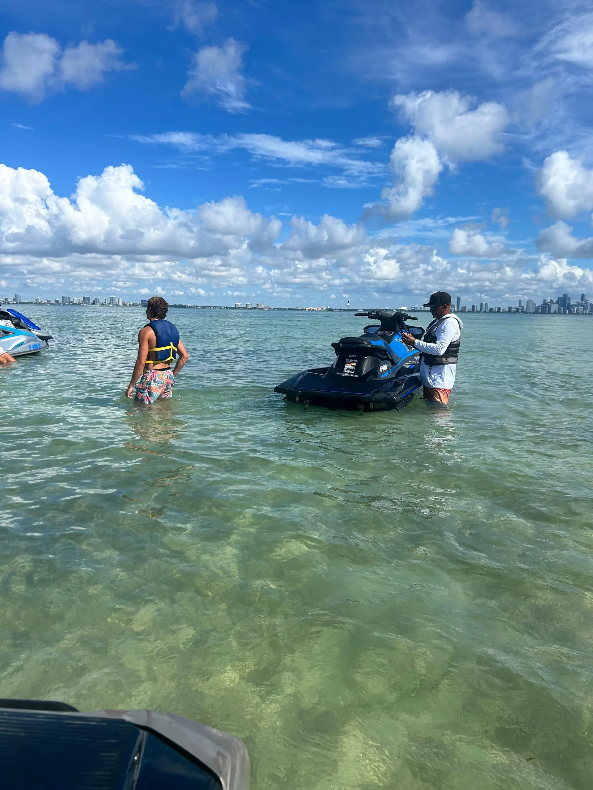 Guide and riders at the West Point Sandbar with crystal clear water and Miami skyline